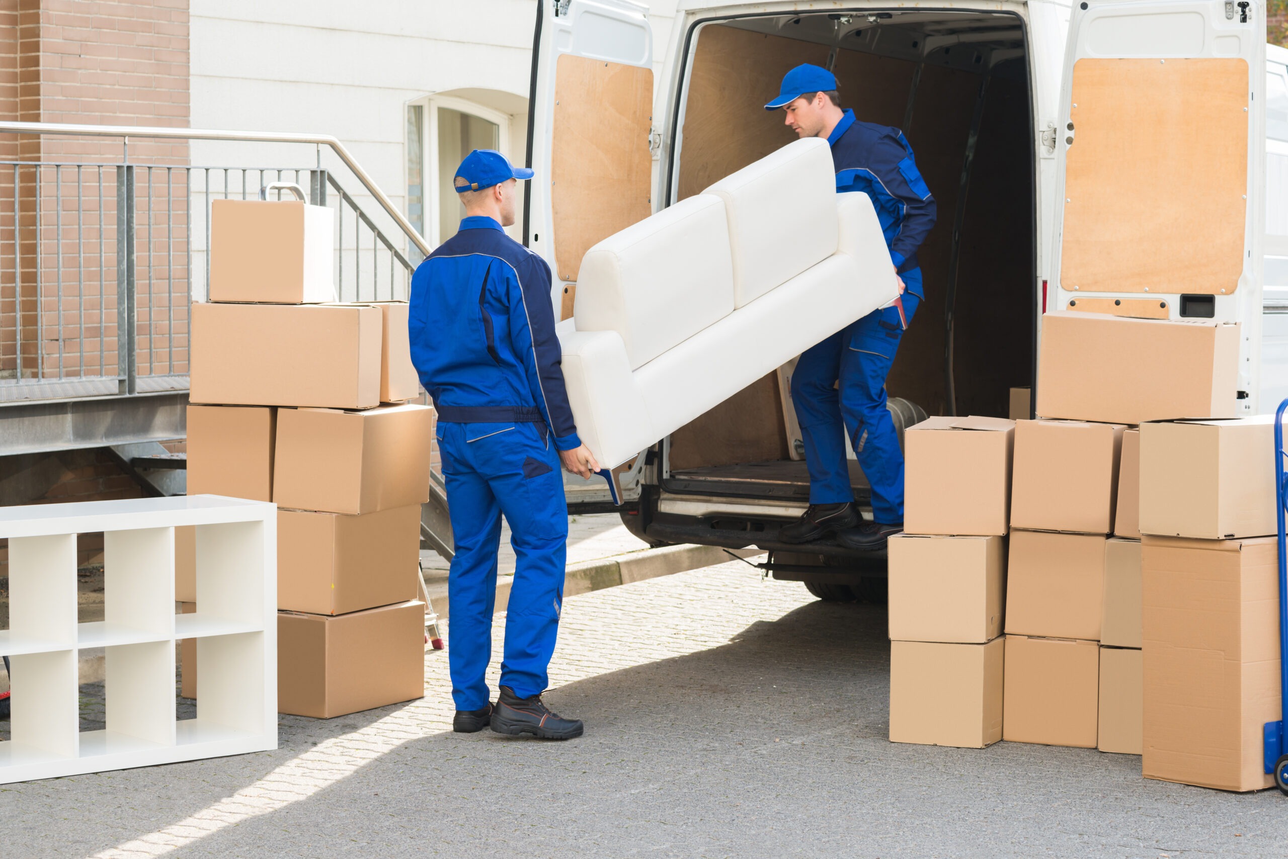 Movers unloading sofa from the truck